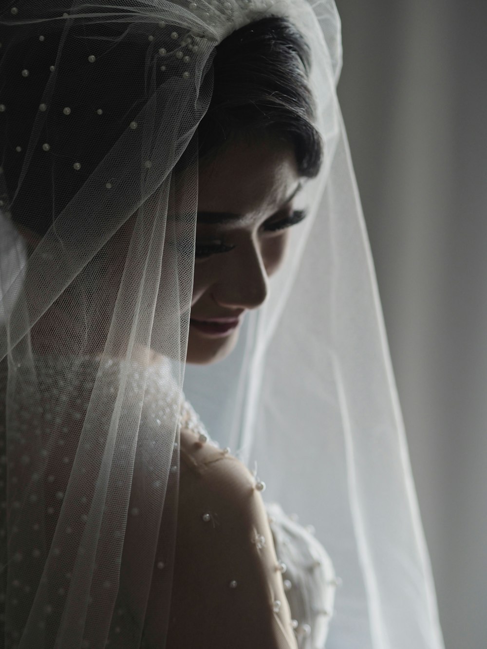 woman wearing white sheer wedding dress standing inside room