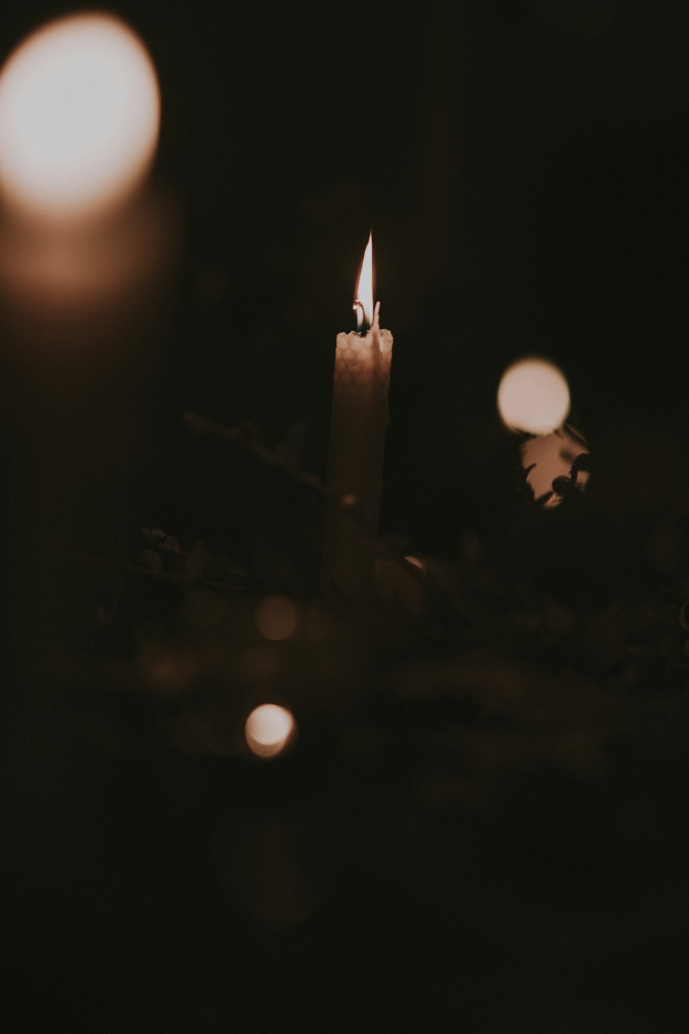 lighted candle inside dark room in bokeh photography