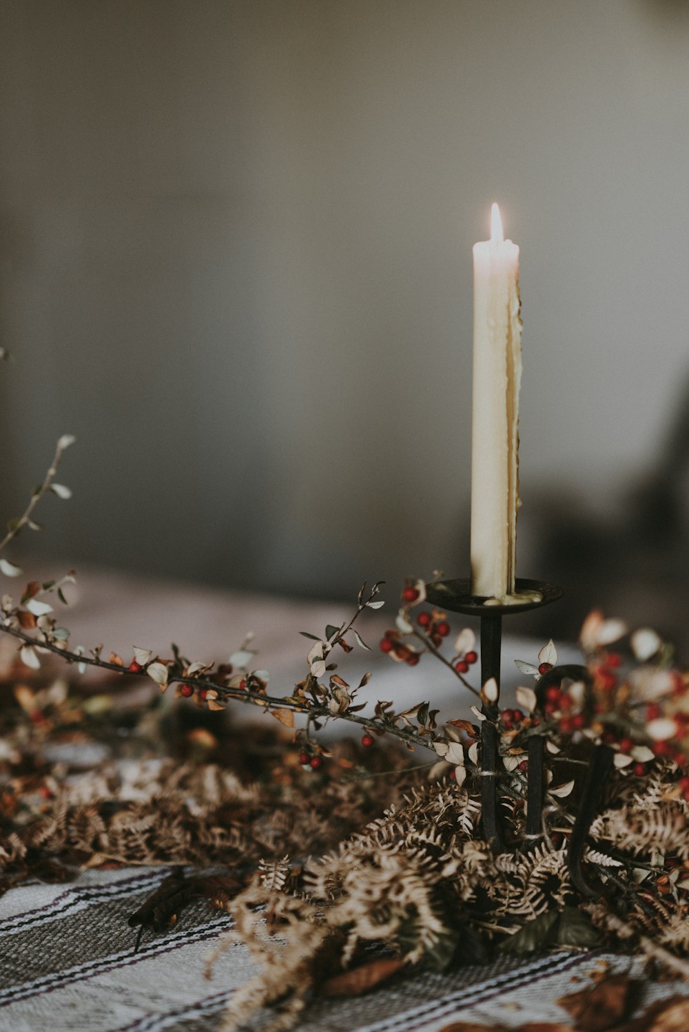 lighted candle on candlestick on top of table