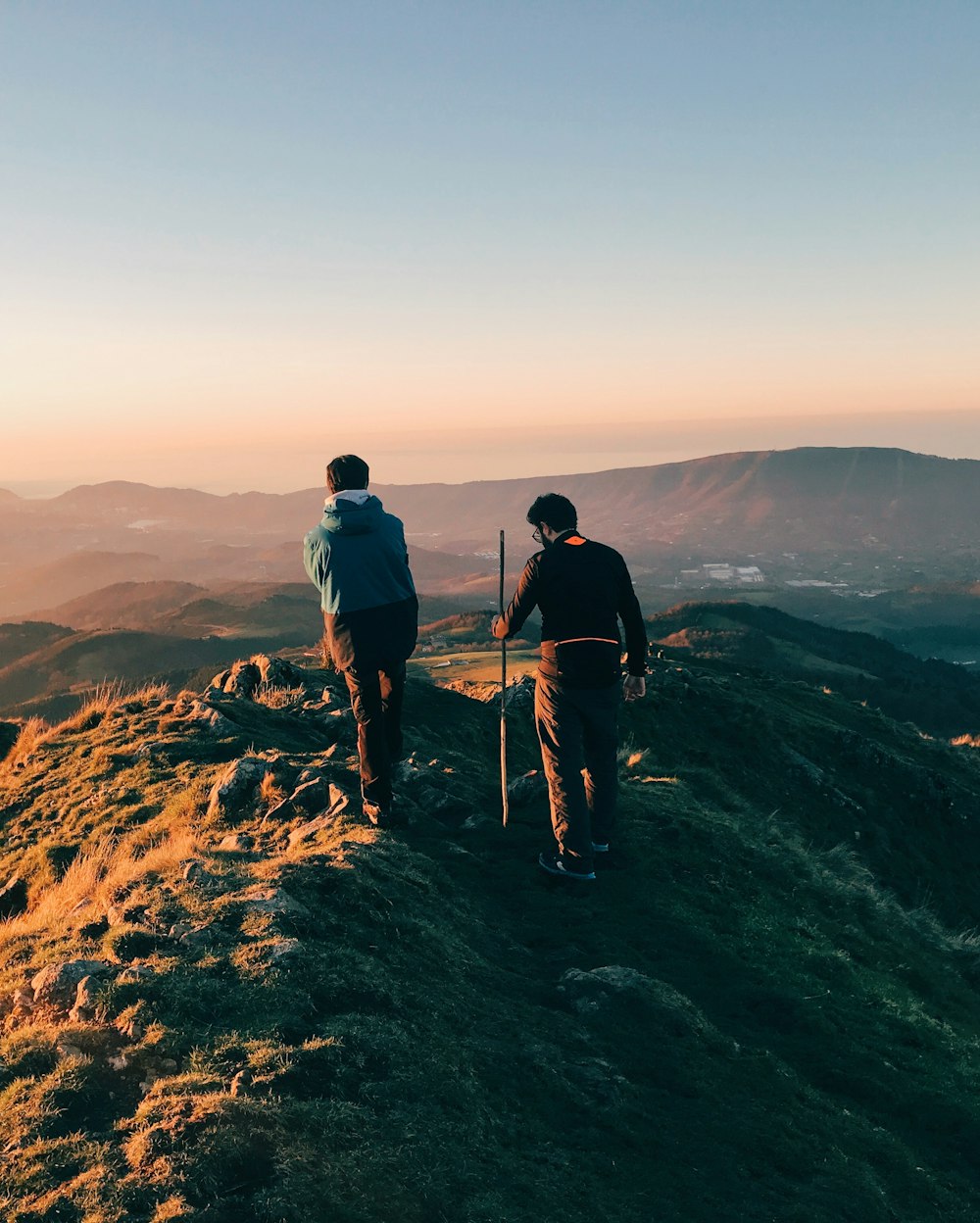 two men on top of mountain under clear blue sky