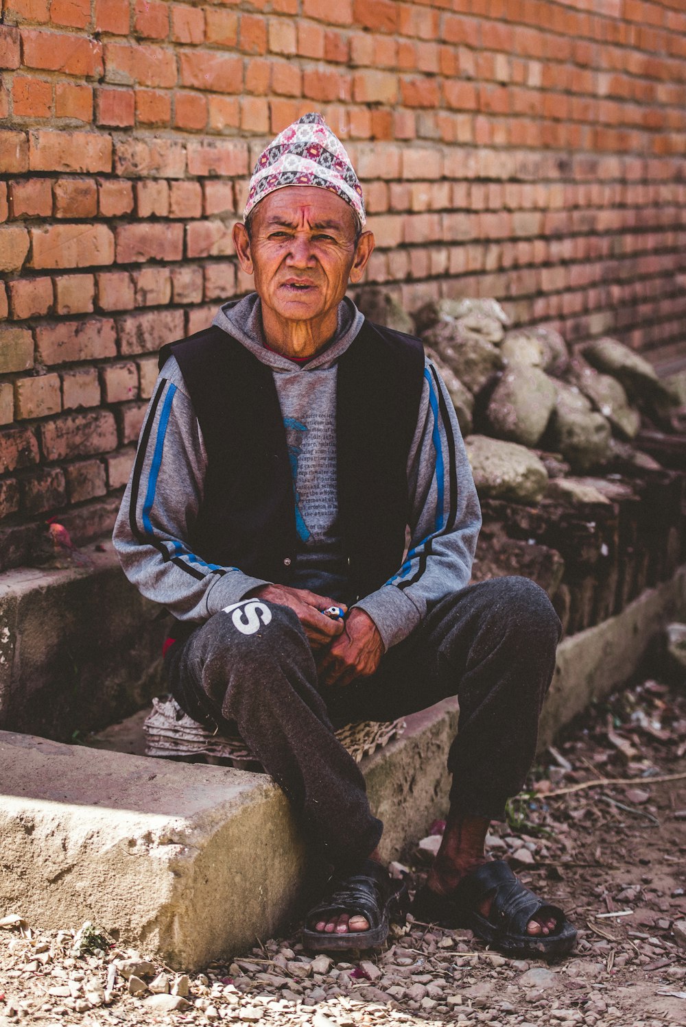 man sitting on gray concrete surface during daytime