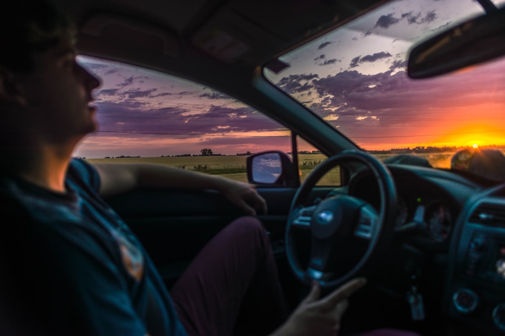 man sitting inside car during golden hour