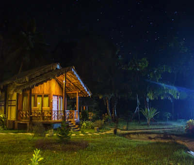 A cozy family chalet nestled among palm trees at sunset in Muscat.