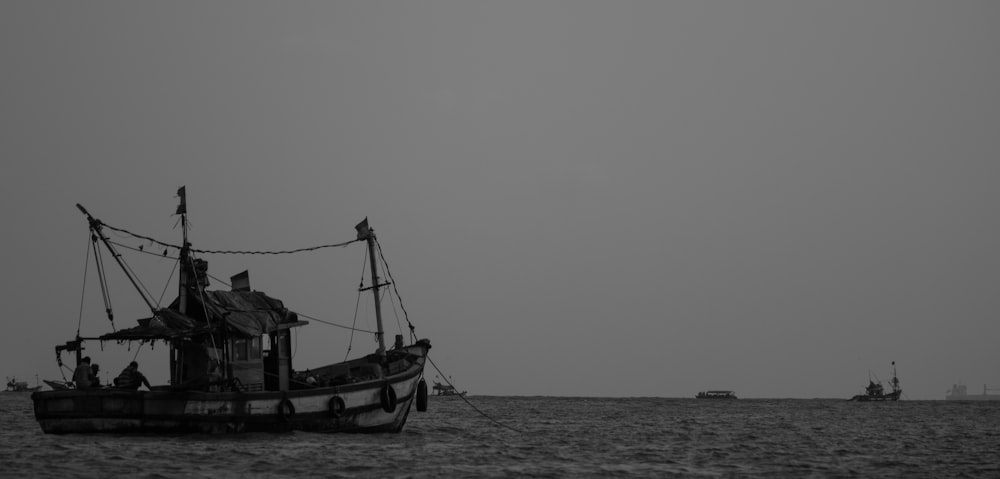 tugboat on body of water in greyscale photography