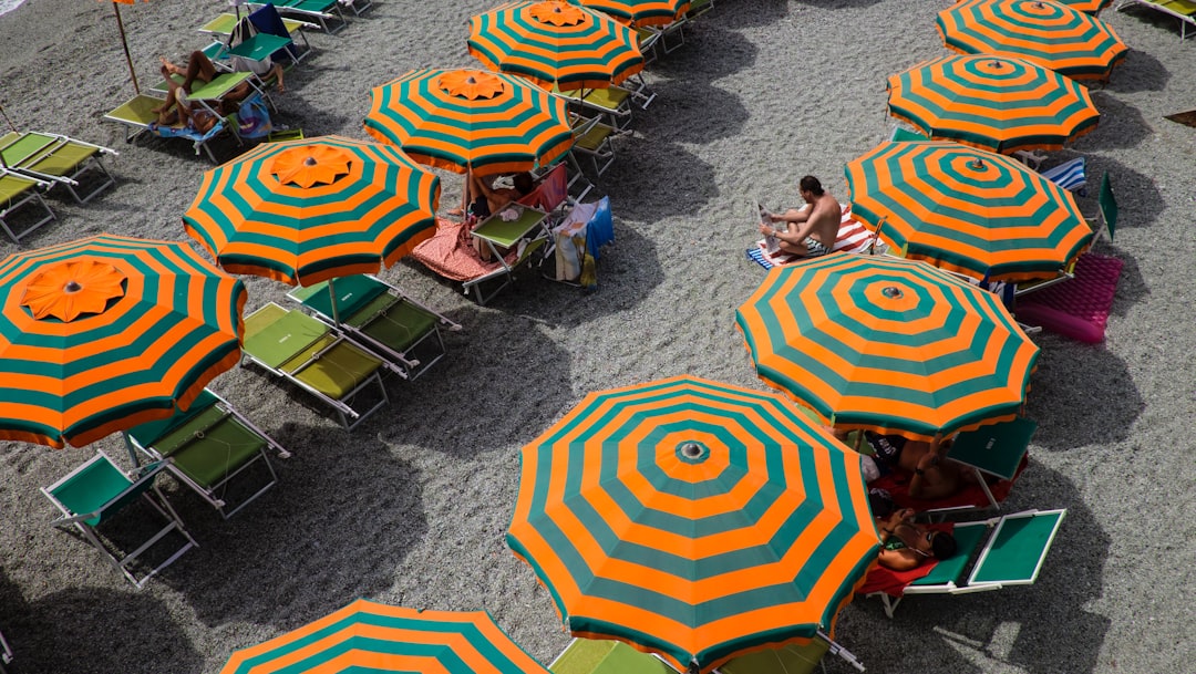 orange and green beach umbrella view, Colourful beach umbrellas seen from above