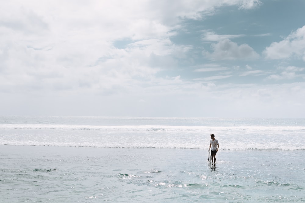 man on shore under white sky