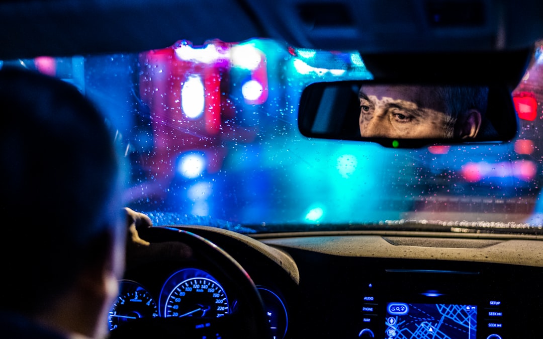 reflective photo of man in rearview mirror