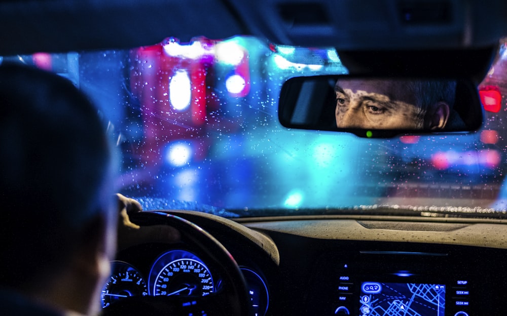 reflective photo of man in rearview mirror