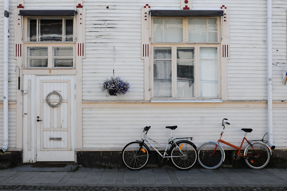 two bicycles parked beside house