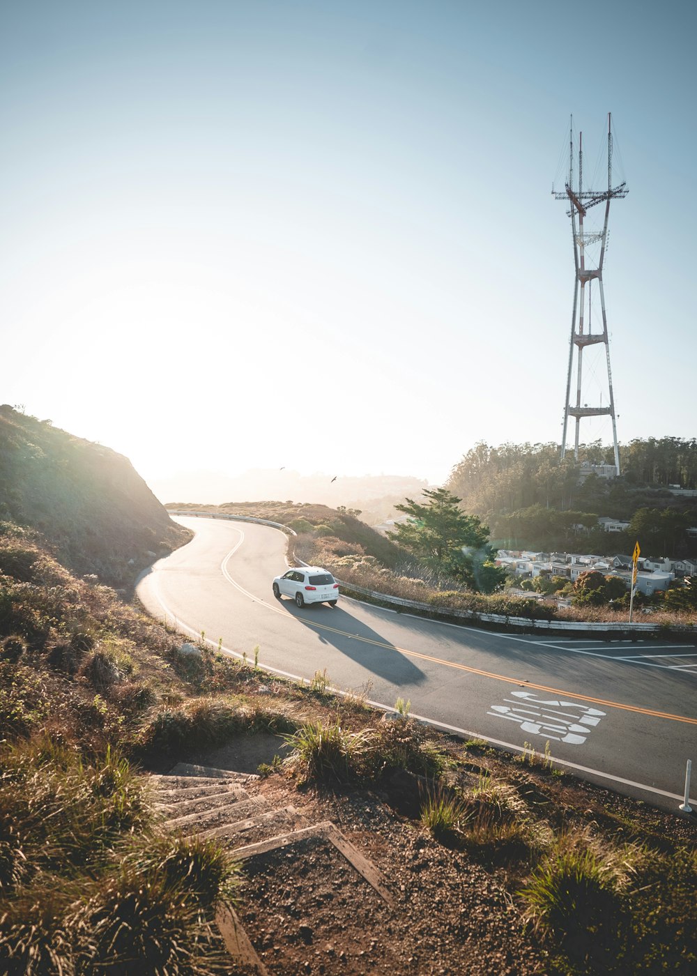 Vehículo blanco en la carretera cerca de la torre eléctrica durante el día