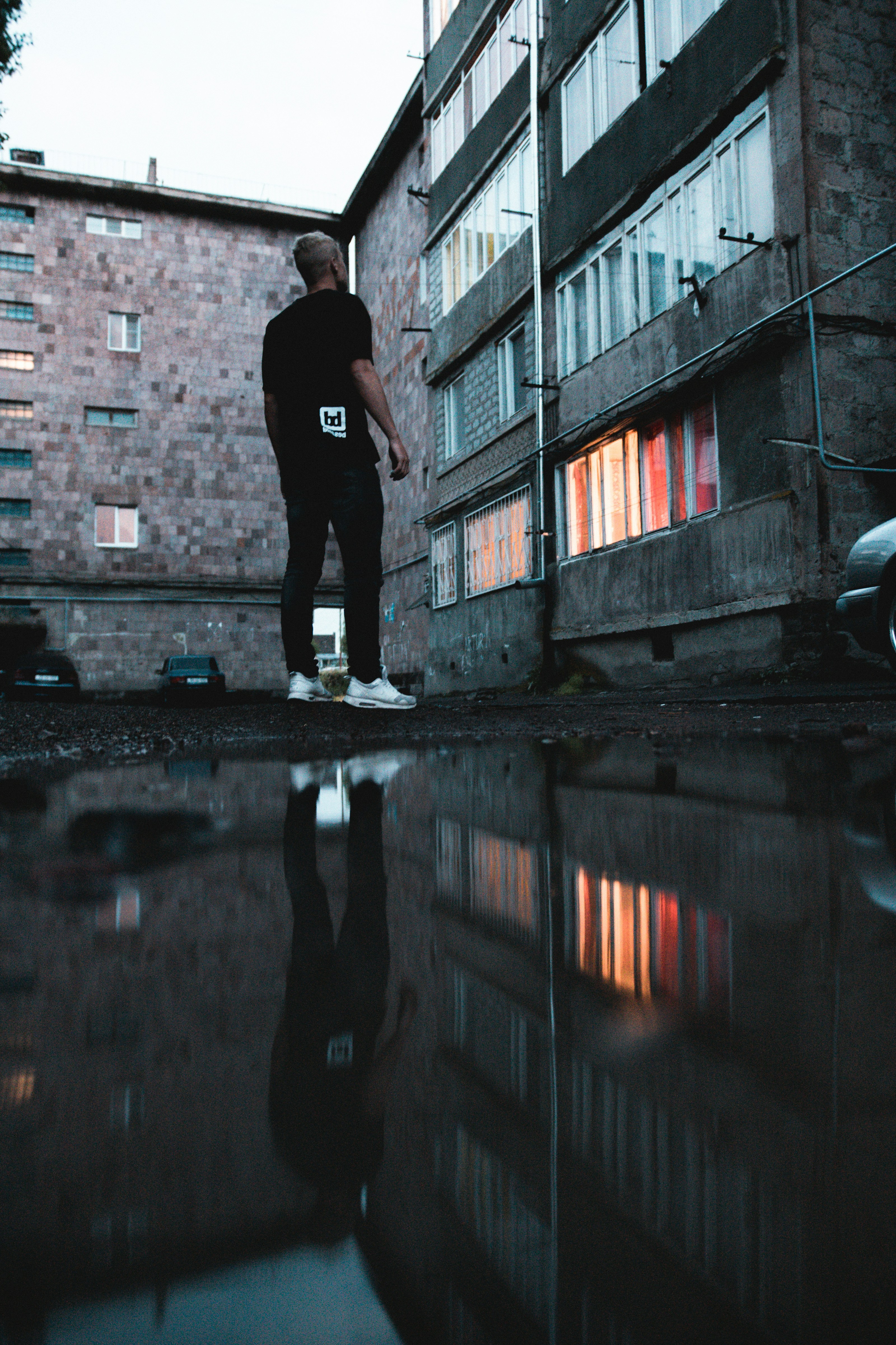 man standing beside concrete building