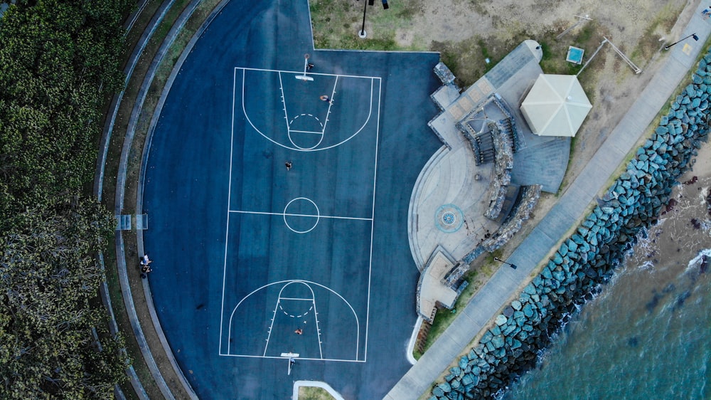 cancha de baloncesto con piso azul junto a la playa
