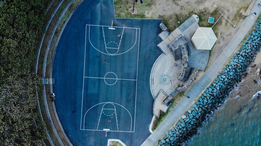 blue floored basketball court by the beach