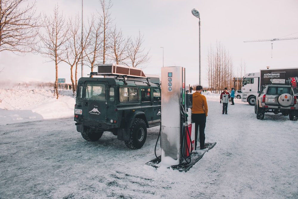Land Rover Defender preto parando em posto de gasolina durante o inverno
