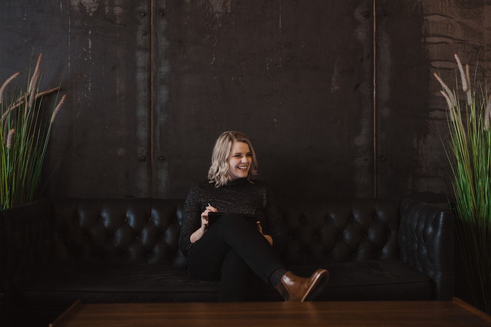 woman sitting on black leather sofa