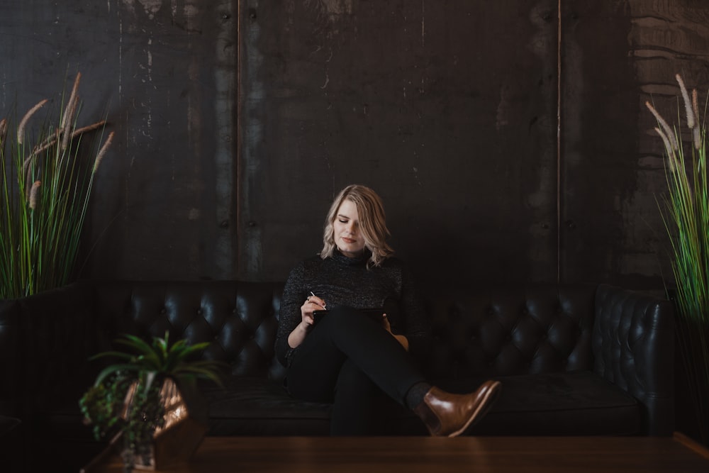 woman sitting on black sofa