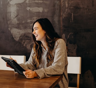 woman sitting around table holding tablet