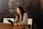 woman sitting around table holding tablet