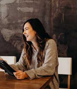 woman sitting around table holding tablet