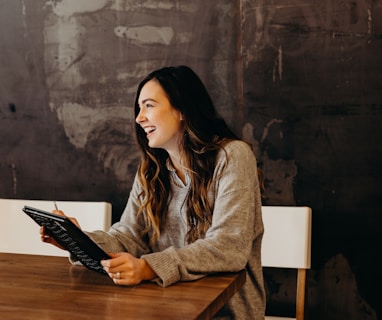 woman sitting around table holding tablet