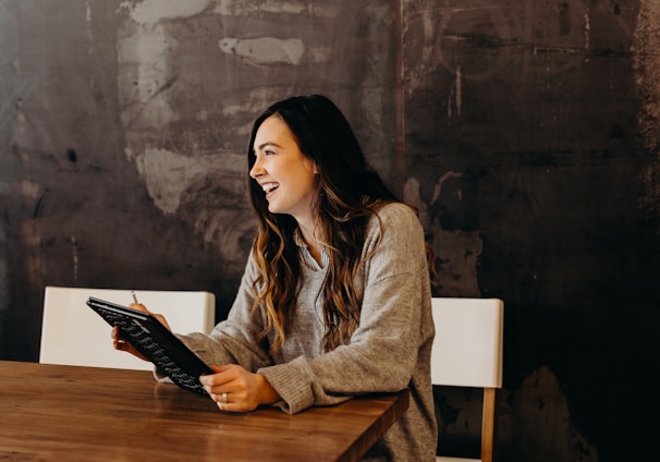 woman sitting around table holding tablet