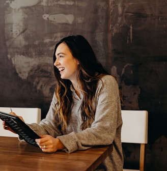 woman sitting around table holding tablet