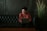 smiling man using laptop computer while sitting on black leather sofa