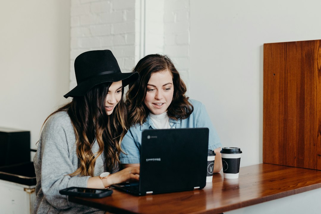 Comment choisir la meilleure formation en gestion de projet à distance pour obtenir une certification reconnue comme PMP ou PRINCE2 ? two woman sitting near table using Samsung laptop