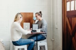 man and woman sitting and using laptops near closed door