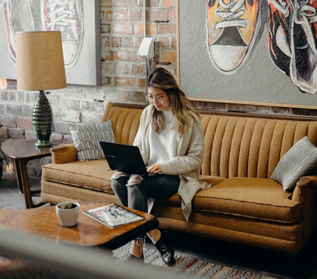 woman using laptop while sitting on chair