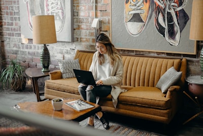 woman using laptop while sitting on chair