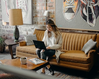 woman using laptop while sitting on chair