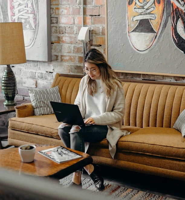 woman using laptop while sitting on chair