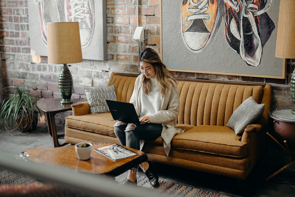 woman using laptop while sitting on chair