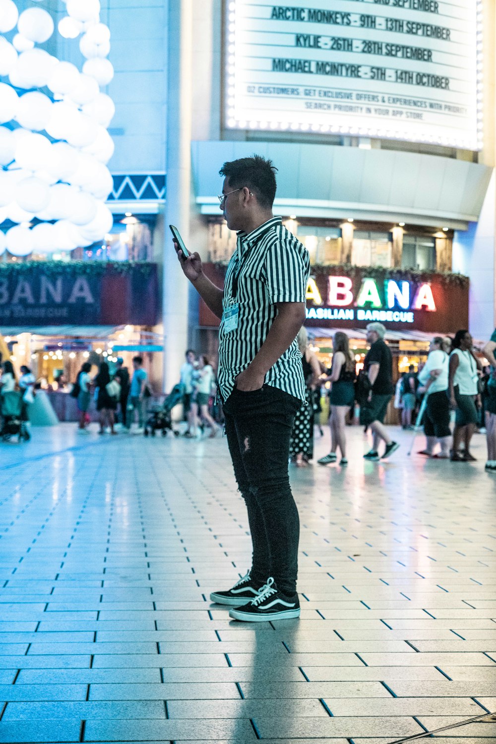 man in black and white striped short-sleeved shirt standing