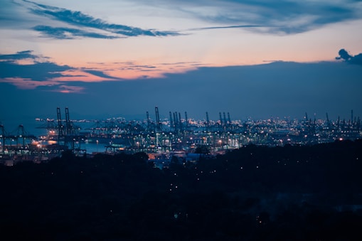 A bustling East African port with cargo ships and cranes at sunset.