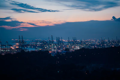 A panoramic view of a bustling international trade port at sunset, symbolizing global finance connections.