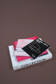 several assorted books stacked on brown surface