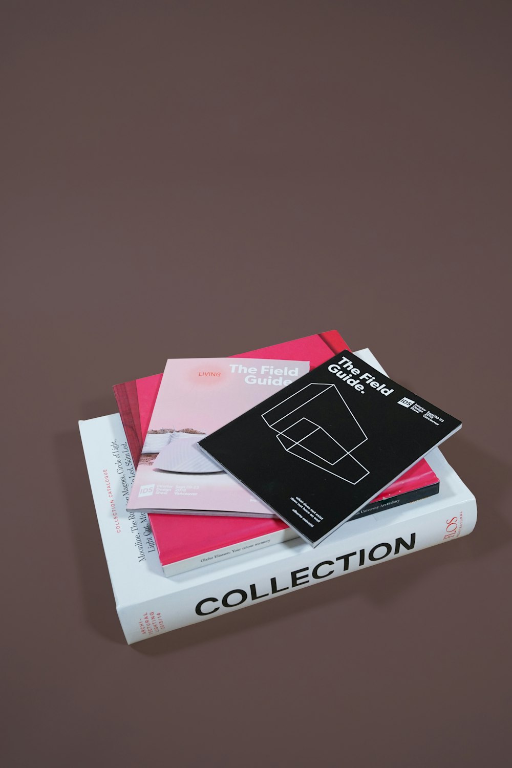 several assorted books stacked on brown surface