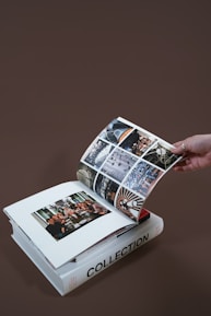 Close-up of hands sorting printed photographs into albums.