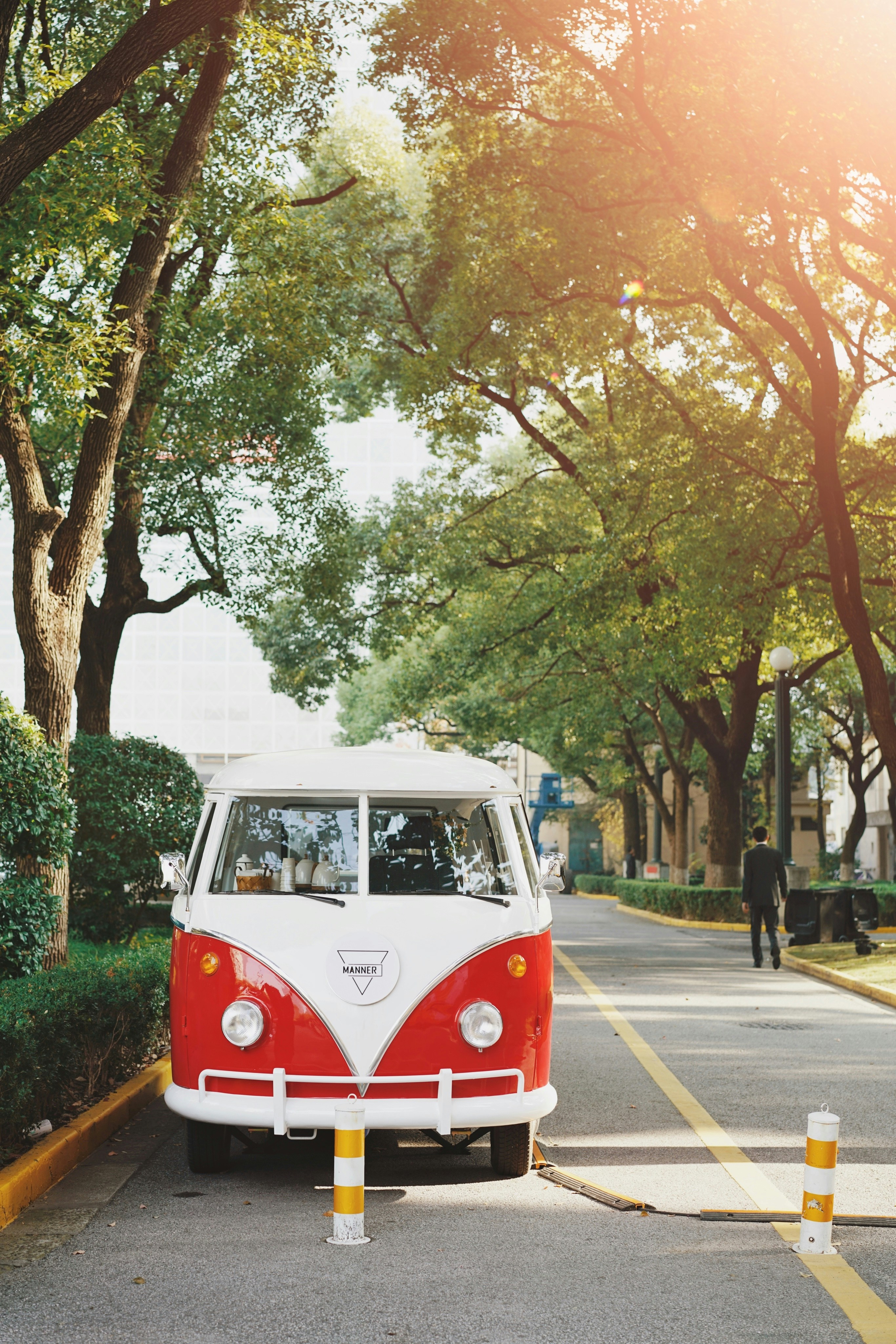 vintage white and red vehicle parked on road beside tree