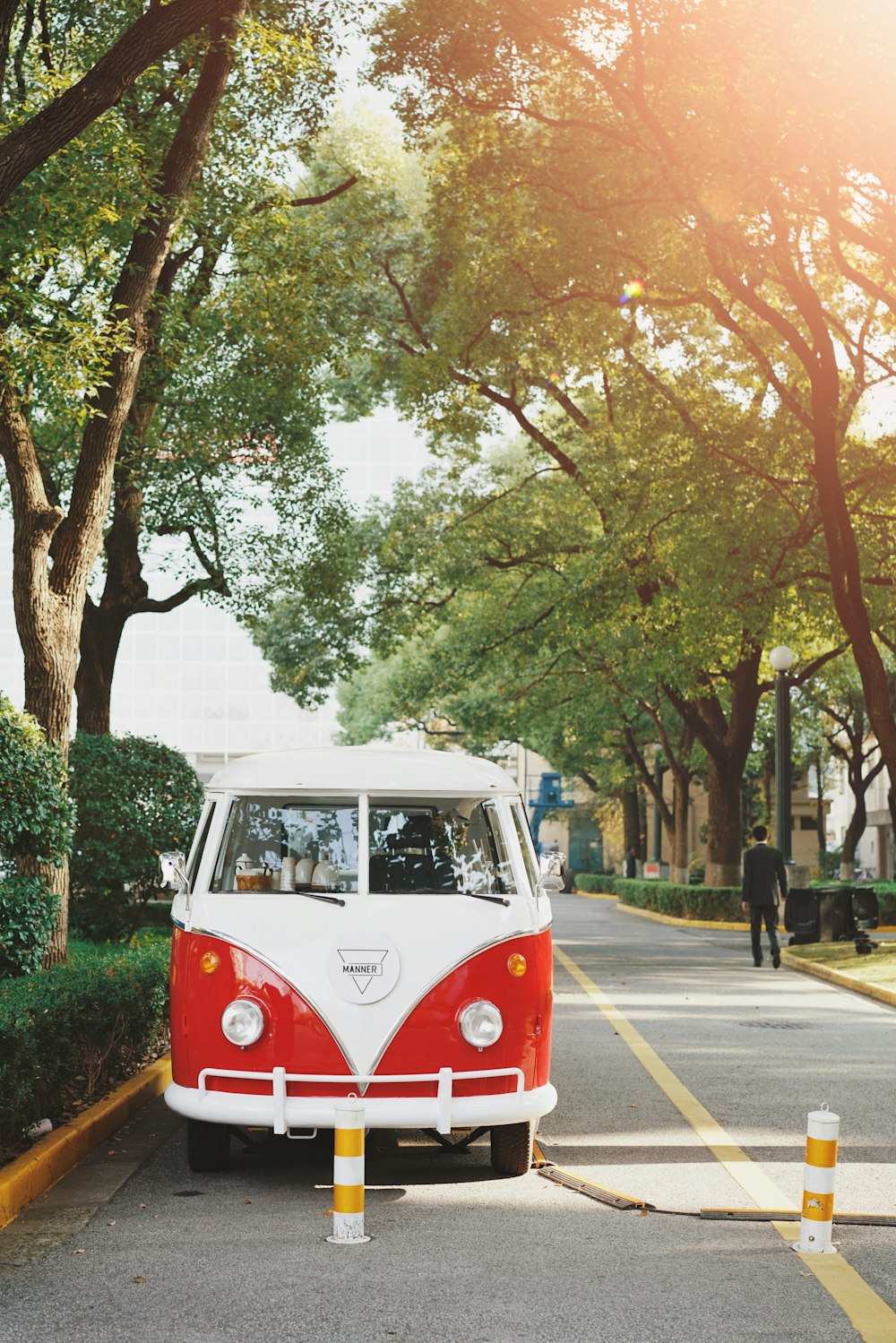 vintage white and red vehicle parked on road beside tree