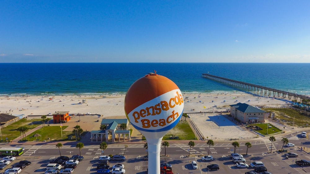 parking lot by the building near beach with orange and blue pensicola beach pole