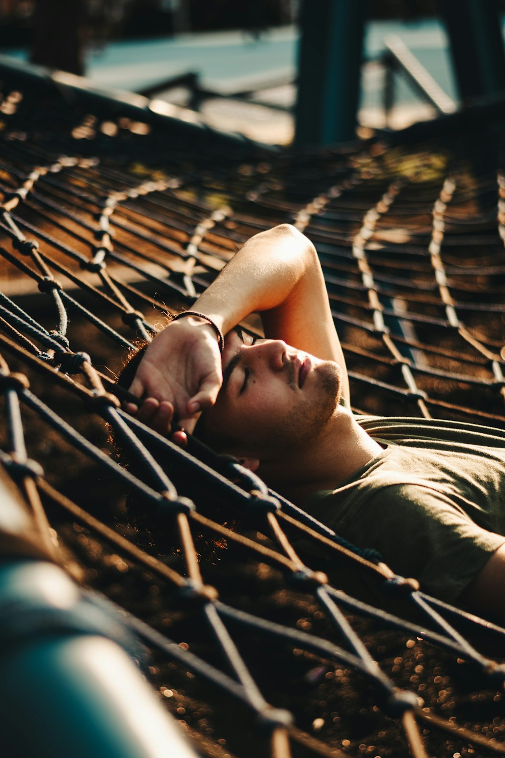 man lying on metal fence