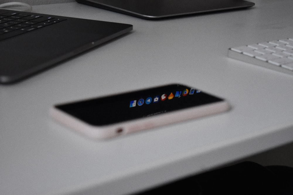 white iPhone 5C beside wireless keyboard
