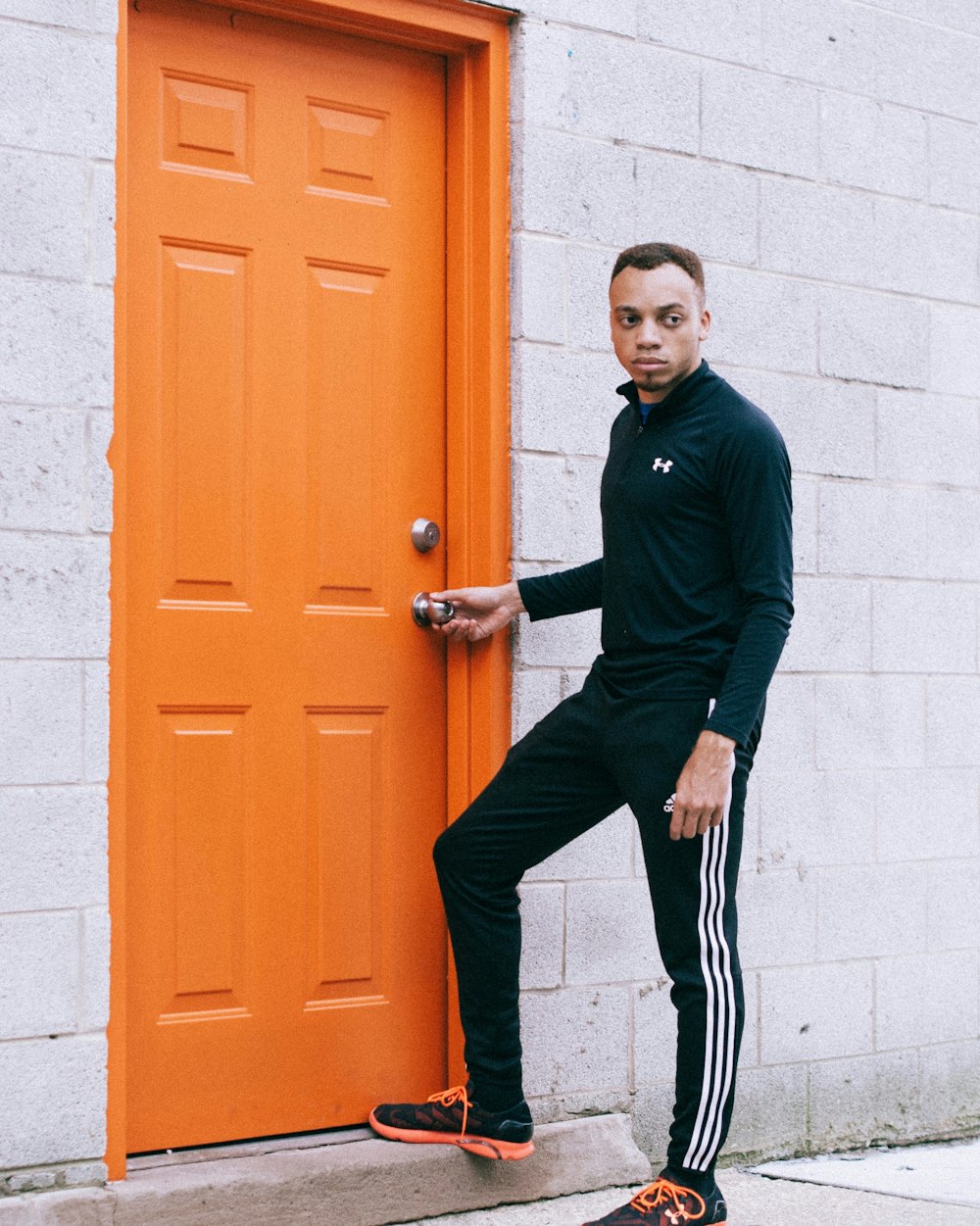 man touching silver door knob