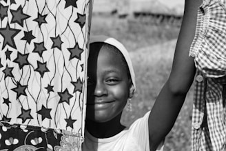 A young girl proudly displaying her handmade craft project with a big smile.