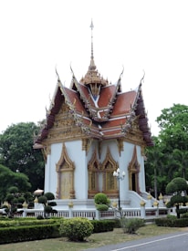 A traditional Thai temple with intricate architecture surrounded by lush greenery.