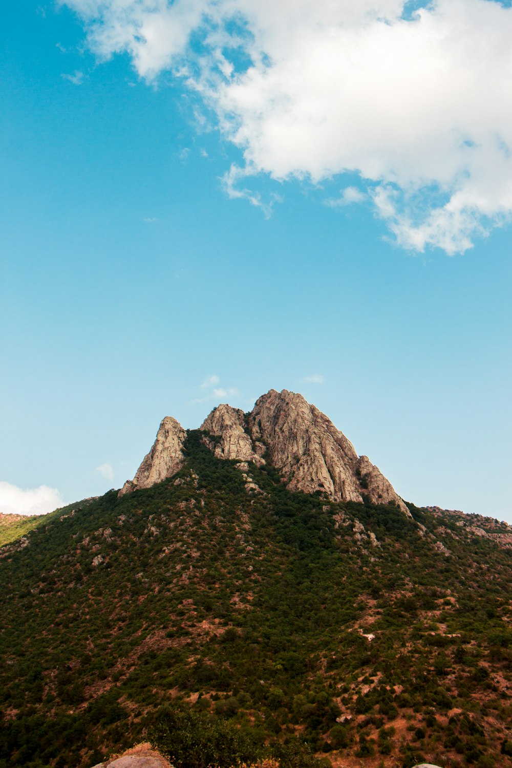 gray rock formation under white cloud and blue sky during daytime