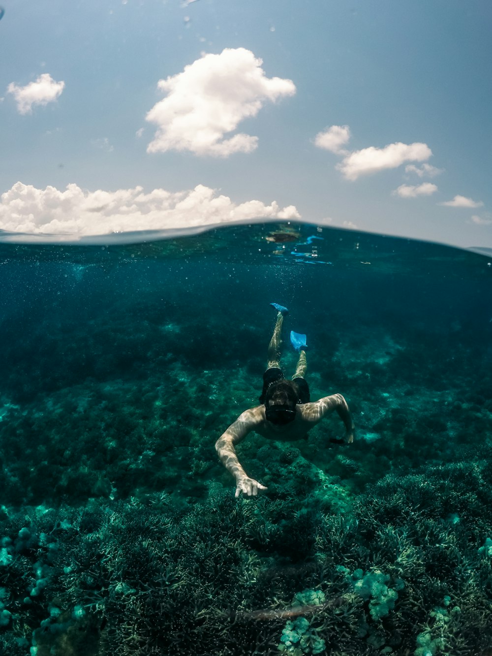 man swimming under clear blue sky